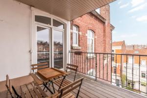 een balkon met een houten tafel en stoelen bij 2 bedroom apartment with terrace, near Lille in Lille