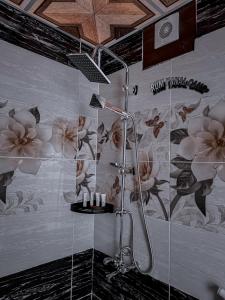 a bathroom with a shower with flowers on the wall at RUM YANAL CAMP in Wadi Rum