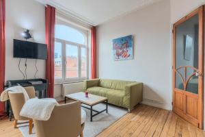 una sala de estar con un sofá y una mesa en 2 bedroom apartment with terrace, near Lille, en Lille