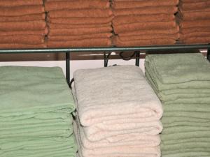 a bunch of towels are on a shelf at Tuktuk House in Kawagoe