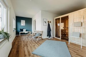a living room with blue walls and wooden floors at Happy Place mit Sauna & Jacuzzi in Plettenberg