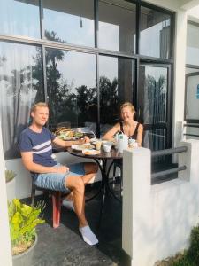 a man and woman sitting at a table eating food at Monarch Ella in Ella