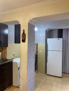 a kitchen with a white refrigerator in a room at Dighomi Apartment in Tbilisi City