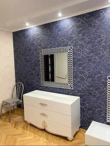 a bathroom with a dresser and a mirror on a wall at Dighomi Apartment in Tbilisi City