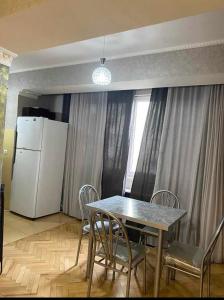 cocina con mesa, sillas y nevera en Dighomi Apartment, en Tiflis