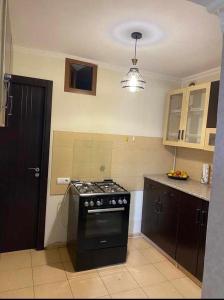 a kitchen with a black stove top oven in it at Dighomi Apartment in Tbilisi City