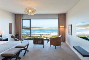 a bedroom with a bed and a view of the ocean at Schulphoek Seafront House in Hermanus