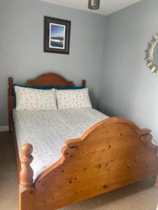1 dormitorio con cama de madera en una habitación en Delightful chalet, overlooking estuary!, en Ferryside