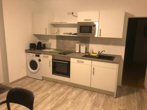 una pequeña cocina con lavadora y microondas en Haus im Grünen en Lippstadt