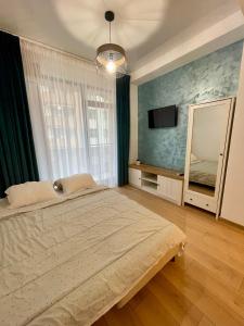 - une chambre avec un grand lit et un miroir dans l'établissement Seaside Apartments Mamaia Nord, à Mamaia Nord – Năvodari