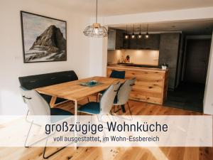 a dining room and kitchen with a wooden table and chairs at Ferienwohnungen Scholl - private Sauna oder Infrarotkabine in Bad Hindelang