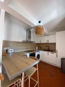 a kitchen with white cabinets and a wooden counter top at Deux chambres avec terrasse dans le centre ville d'Aix en Provence in Aix-en-Provence