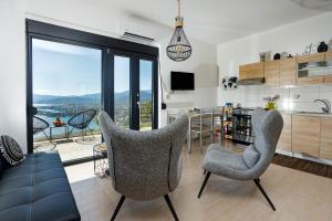 uma sala de estar com duas cadeiras e uma cozinha em Endless View Apartment em Elliniká