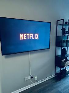 a large screen with the netflix sign on a wall at Delightful 1-bed Apt with Free Parking and Wi-fi by HP Accommodation in Milton Keynes