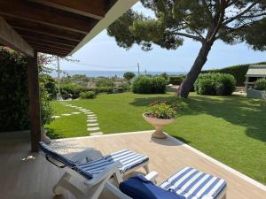 two lounge chairs on a porch with a yard at Italianflat - Villa Andrea Doria in Costa Rei