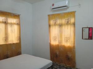 a room with two curtains and a bed in it at Homestay Idaman B B with 2 room aircond 2 Quen Bed and Not Sharing Room -Privacy in Kuala Terengganu