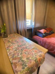a room with a bed and a table with a flower blanket at Apartament Asspazja in Stronie Śląskie