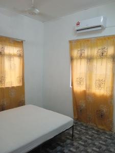 a room with a bed and a window with curtains at Homestay Idaman B B with 2 room aircond 2 Quen Bed and Not Sharing Room -Privacy in Kuala Terengganu