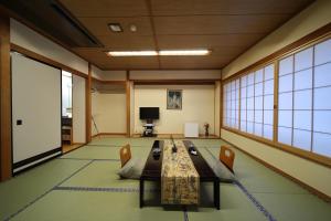 Habitación grande con mesa y sillas. en Saga Grace Hotel en Kioto