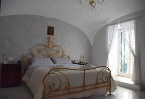 Un dormitorio con una cama grande con sábanas blancas y una lámpara de araña. en Civico 30, en Nápoles