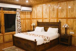 a bedroom with a bed in a room with wooden walls at Jewel Of Kashmir House Boat in Nagīn Bāgh