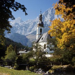 eine Kirche mit einem Berg im Hintergrund in der Unterkunft Appartement Zeitz Ramsau in Ramsau bei Berchtesgaden