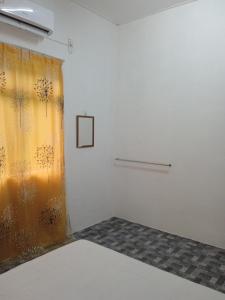 a room with a bed and a curtain with flowers at Homestay Idaman B B with 2 room aircond 2 Quen Bed and Not Sharing Room -Privacy in Kuala Terengganu