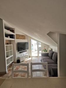 a living room with a couch and a tv at Appartamento mansardato Civitanova Marche in Civitanova Marche