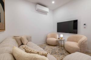 a living room with a couch and two chairs and a flat screen tv at Beach Townhouse - Luxury, Wi-Fi, AC, 2 mins from the beach in Armação de Pêra