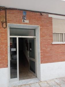 una puerta abierta a un edificio de ladrillo con aparcamiento en Apartamento Islu, en Peñíscola