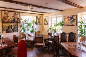 a restaurant with tables and chairs and plants at Karja Accommodation in Haapsalu