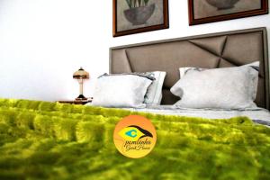 a bedroom with a bed with a green blanket at GuestHouse Pombinha in Nazaré