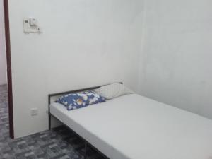 a bed in a room with a white wall at Homestay Idaman B B with 2 room aircond 2 Quen Bed and Not Sharing Room -Privacy in Kuala Terengganu