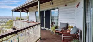a porch with two chairs and a table on a balcony at Eagle's Nest in Stanthorpe