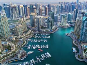 45 Mins drive to Dubai Marina and The Beach at JBR في الشارقة: اطلالة جوية على مدينة بها قوارب في الماء