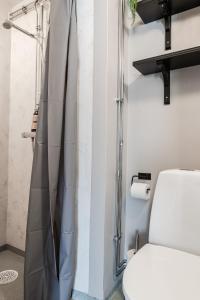 a bathroom with a shower curtain next to a toilet at Guestly Homes - Business & Comfort in Boden