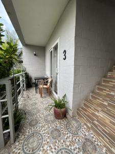 eine Veranda mit Fliesenboden und Treppe neben einem Haus in der Unterkunft Ginger Sihanoukville in Sihanoukville