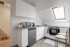 een keuken met witte kasten en een magnetron bij Beautiful fully renovated apartment in Brussel