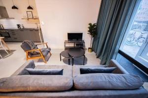 a living room with a couch and a table at Warm 2 Bedroom Serviced Apartment 59m2 -LK21- in Rotterdam