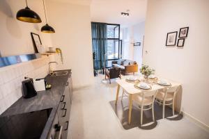 een keuken en een woonkamer met een tafel en stoelen bij Warm 2 Bedroom Serviced Apartment 59m2 -LK21- in Rotterdam