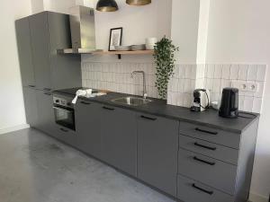 cocina con fregadero y fogones en Stylish 2 Bedroom Serviced Apartment in Rotterdam en Róterdam