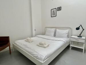ロッテルダムにあるStylish 2 Bedroom Serviced Apartment in Rotterdamの白いベッド(タオル付)が備わるベッドルームです。