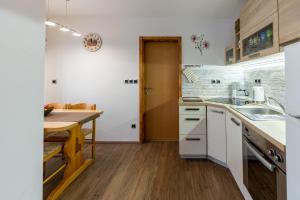 eine Küche mit weißen Schränken und Holzböden in der Unterkunft Apartma pri Andreju in Bohinj