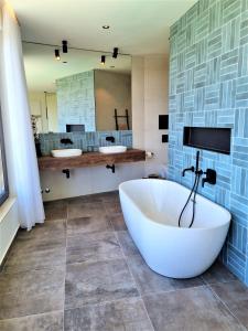 uma casa de banho com uma banheira grande e um espelho grande em Villa Lumi em Porec