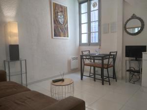 uma sala de estar com um sofá e uma mesa em "Sous les Voûtes" -Garage privé optionnel -Centre historique-Plages à 21km ! em Pézenas