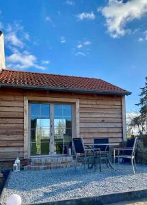 a house with two chairs and a table outside at Ferienhaus Melzower Waldhaus Montagewohnung in Melzow