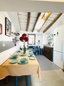 eine Küche mit einem Tisch mit blauen Platten und roten Blumen in der Unterkunft Calle Villa Baja Castril in Castril