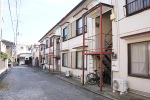 伊东IG1 無料温泉チケット付 宇佐美 お宿一期二笑 Oyado IchigoNie的建筑物之间的小巷里的一条空荡荡的街道