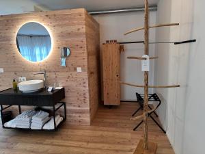 a bathroom with a wooden wall with a mirror at Hotel & Glamping Gerhardhof by ALPAMI in Wildermieming +57 photos