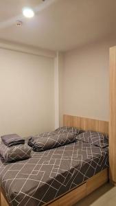 - un lit avec un cadre en bois dans une chambre dans l'établissement 2 BR The Oak Tower Apartment 9th Floor, à Jakarta